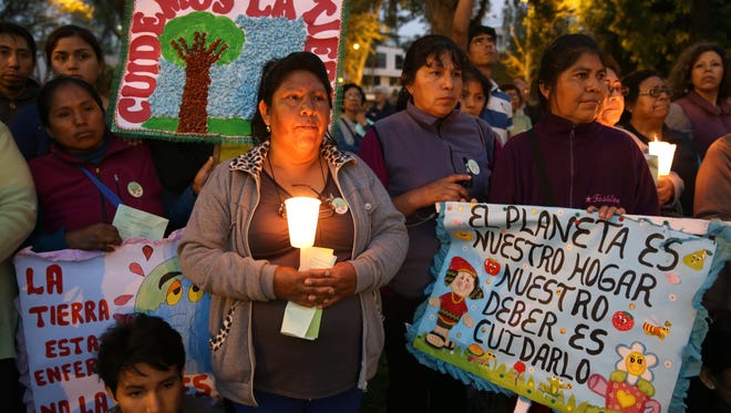 Hundred of participants attend a candlelight vigil, a day before the inauguration of Climate Change Conference in Lima, Peru, Sunday.