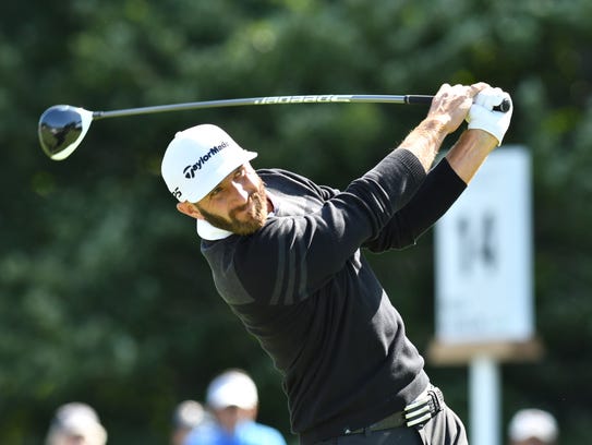 Dustin Johnson hits his tee shot on the 14th hole during