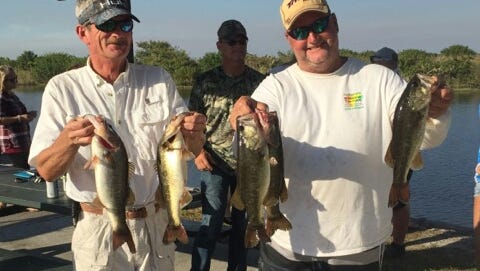 Bill Pfaff and Capt. JoGene Holaway holding up several largemouth black bass, which earned them third place in the United Bass Anglers Sportsman Series fishing tournament at Lake Okeechobee. Each bass was caught using a Hilderbrandt Spinner as bait.