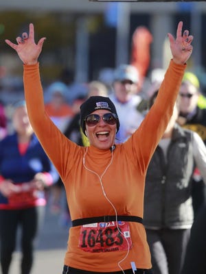 Robyn Gilleran, 41, of Franklin celebrates after finishing the half marathon during the 37th Annual Detroit Free Press/Talmer Bank Marathon on Oct. 19, 2014.