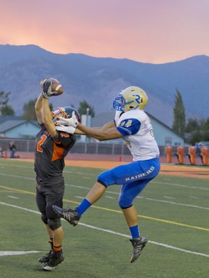 Mason Rhoads of the Douglas Tigers steps in front of Trae Carter-Wells of the Reed Raiders for an interception in a 2013 game.