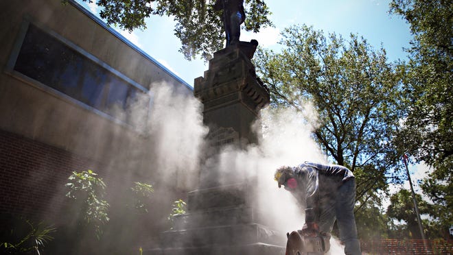 In an August 2017 photo, a concrete saw is used to remove the base of a Confederate monument, known by locals as Old Joe, near the corner of West University Avenue and South Main Street in Gainesville.