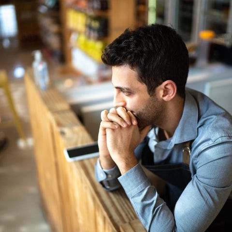 A worried person in an office leaning their chin o