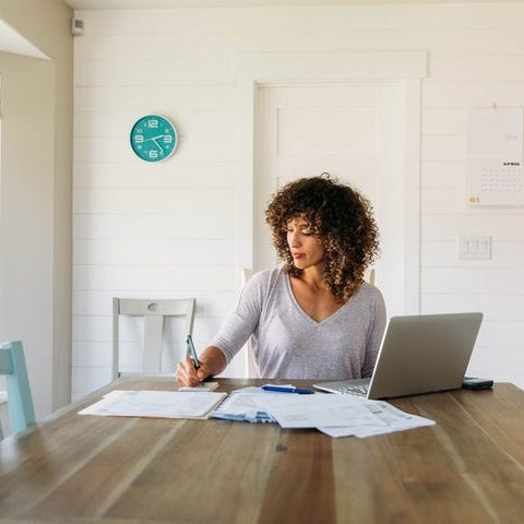 A woman sitting at a sunny kitchen table with her 