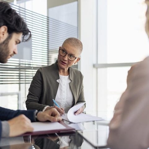 A woman reviews a couple's financial statments at 