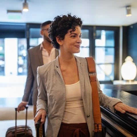 A smiling business traveler arrives at a hotel des