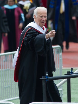 Joe Biden, Vice President of the United States, waves to the crowd as he enters Alumni Stadium for the 128th commencement ceremony at Delaware State University.