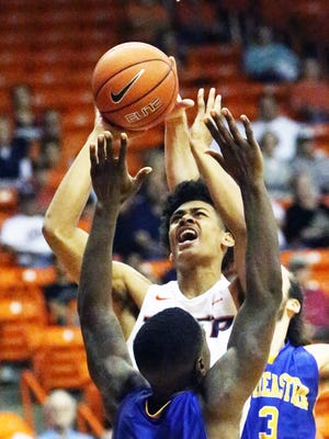 UTEP freshman guard Tim Cameron muscles his way to a layup attempt against Anton Cook, 12, and Gianpalo Riccio, 3, of Southeastern Oklahoma State Sunday at the Don Haskins Center.
