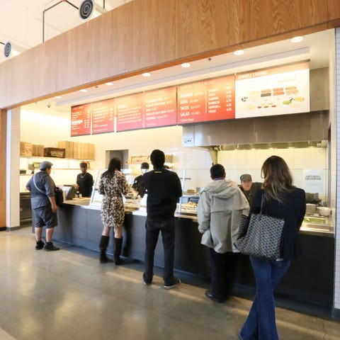 Customers waiting on line at a Chipotle restaurant
