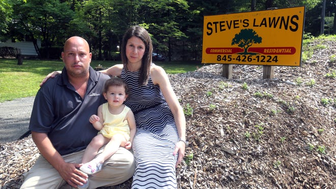 Steve Slackman, owner of Steve's Lawns, won a court decision against Chestnut Ridge. The judge ruled the village purposely changed its zoning to put his landscaping company out of business. He was photographed Tuesday with his wife, Laurie, and 1-year old daughter Cayla.