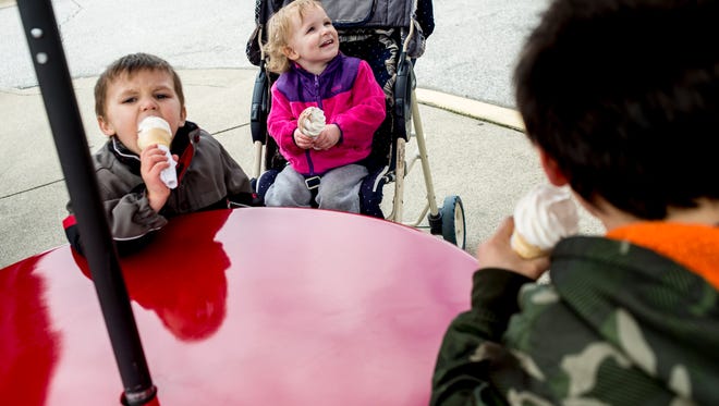 Zander Martin, 4, Bella Harder, 2, and Oden Evenson, 10, of Port Huron, have ice cream together with family friends during free cone day Friday, April 1, 2016 at Jimmy's Frozen Custard in Port Huron.