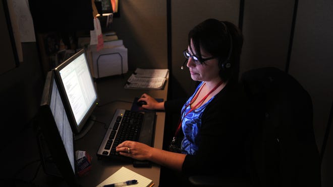A Department of Children’s Services case manager listens to a child abuse hotline call.