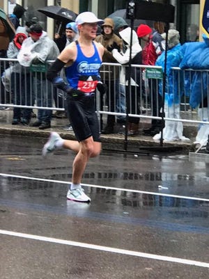 Adrian Macdonald of Fort Collins runs through the wind, rain and cold Monday to finish 56th overall in the Boston Marathon.