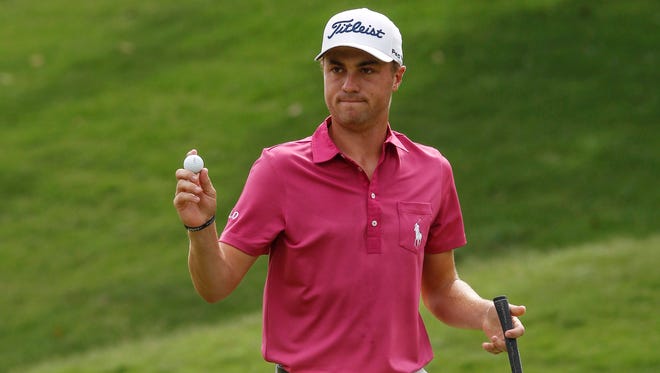 Justin Thomas of the United States acknowledges the crowd after putting on the first green during the final round of the CIMB Classic golf tournament at Tournament Players Club (TPC) in Kuala Lumpur, Malaysia, Sunday, Oct. 23, 2016. (AP Photo/Joshua Paul)