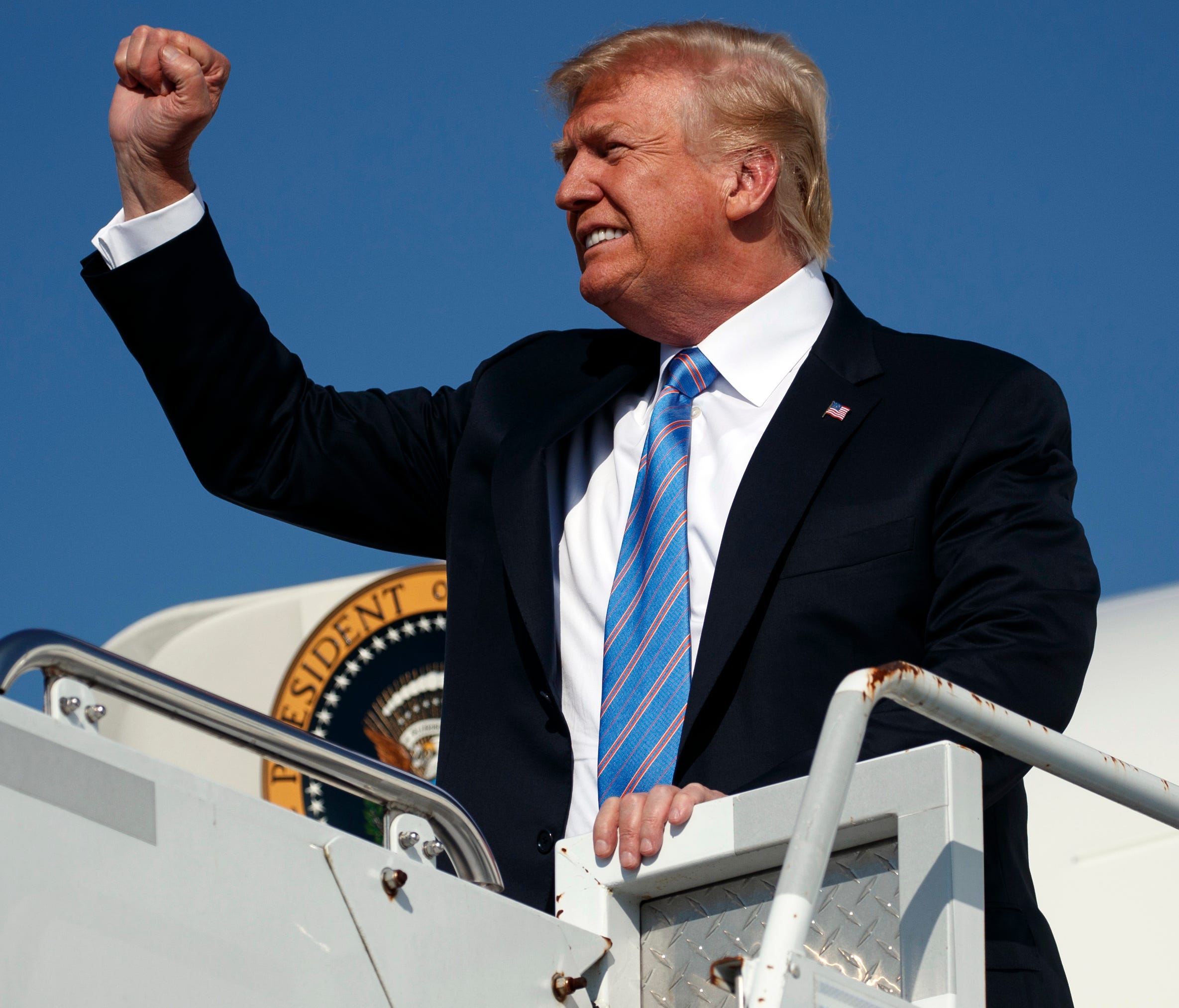 President Donald Trump pumps his fist as he arrives at the Greenbrier Valley Airport in Lewisburg, West Virginia.