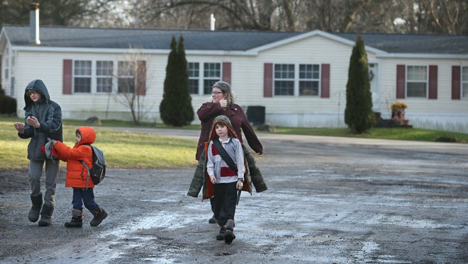 Pamela Haines and her sons Brandon, 14, Aidan, 9, and Trysten, 5, head home after she picked the two youngest up at the bus stop following school.
