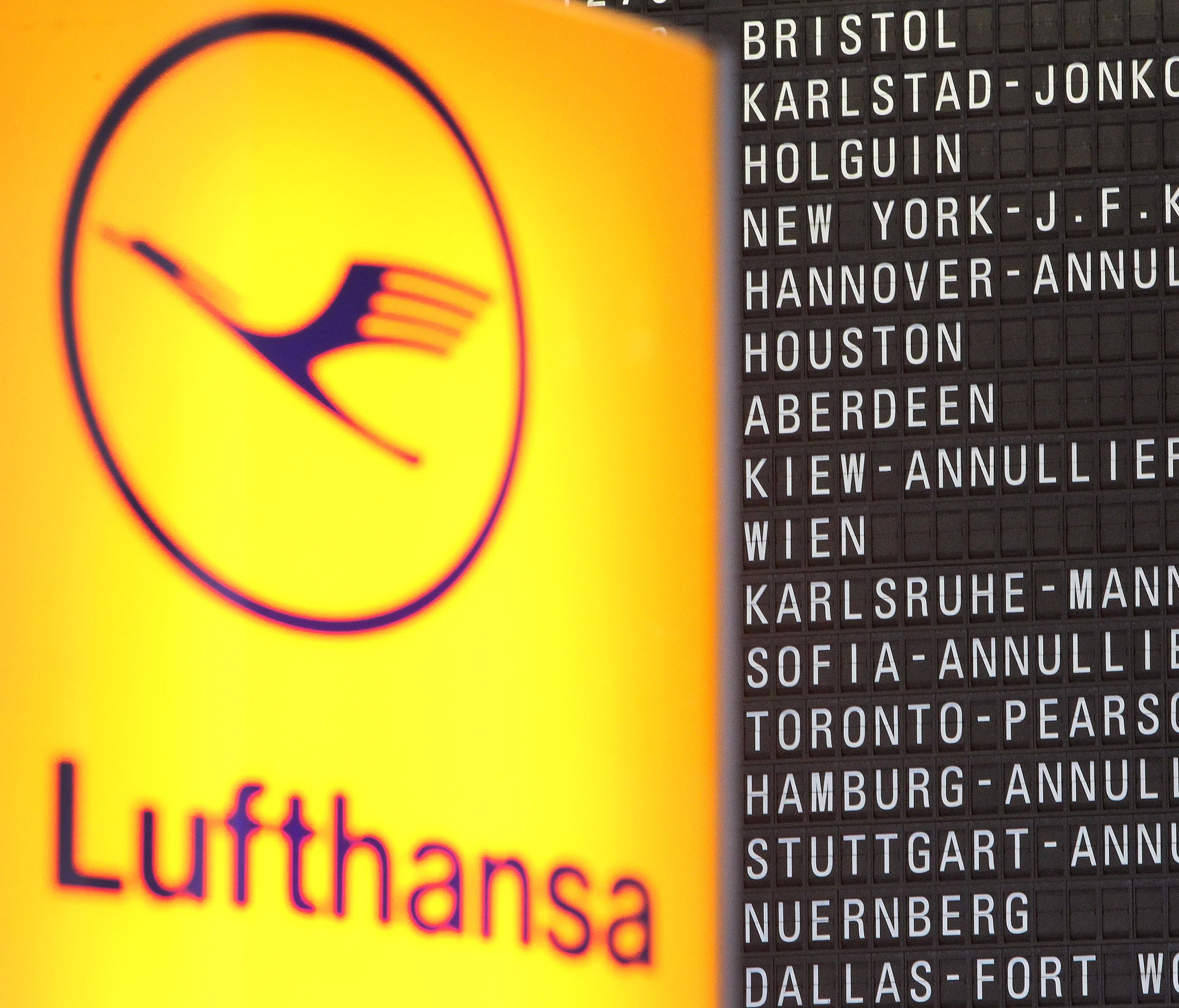 In this file photo from Nov. 23, 2016, a flight-display board showing canceled flights is seen next to a Lufthansa logo at the Frankfurt Airport.
