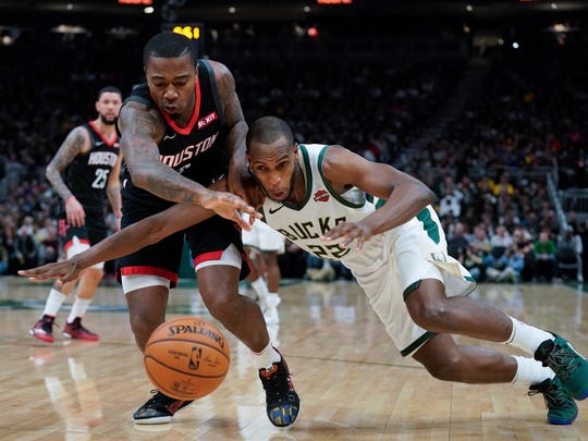 Houston Rockets' Gary Clark and Milwaukee Bucks' Khris Middleton go after a loose ball during the second half of an NBA basketball game Tuesday, March 26, 2019, in Milwaukee. The Bucks won 108-94. (AP Photo/Morry Gash)