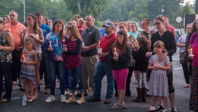 About 100 people attend a vigil for Stormie Harrell, 7, and her sister, Sidney Michaela Dowdy, 17, in front of Alyssa's Antique Depot in Pace on Monday, May 14, 2018. The sisters were killed when a suspected DUI driver hit the car their mother, Melanie Harrell, was driving on May 6.
