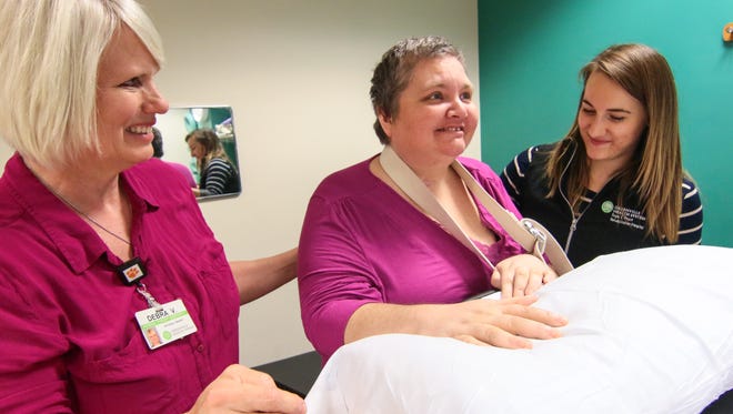 Physical therapists Debra Van Slooten, left, and Lindsay Olson, right, help Dee Loner, center, during a session at the Roger C. Peace Rehabilitation Hospital in Greenville. Loner, a longtime teacher, suffered a brain injury in August 2015.
