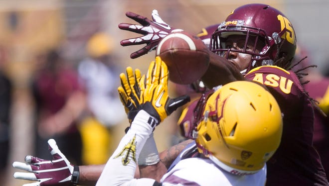 ASU defensive back Solomon Means (back right) breaks up a pass intended to ASU wide receiver Frederick Gammage during the ASU football spring game at Sun Devil Stadium in Tempe on Saturday, April 19, 2014.