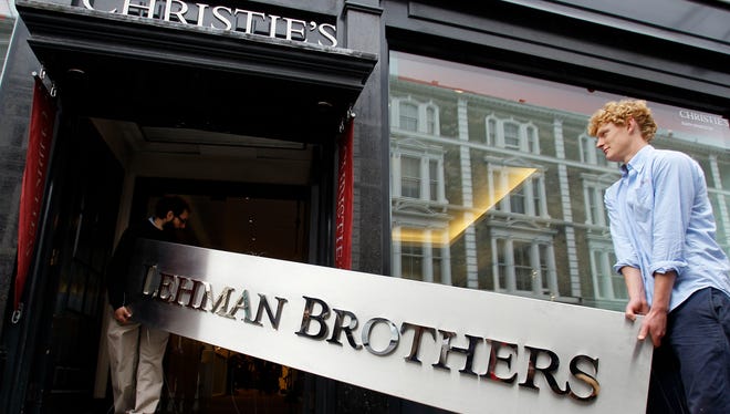 The Lehman Brothers corporate sign in polished metal is taken into an auction house in London, Friday, Sept. 24, 2010.