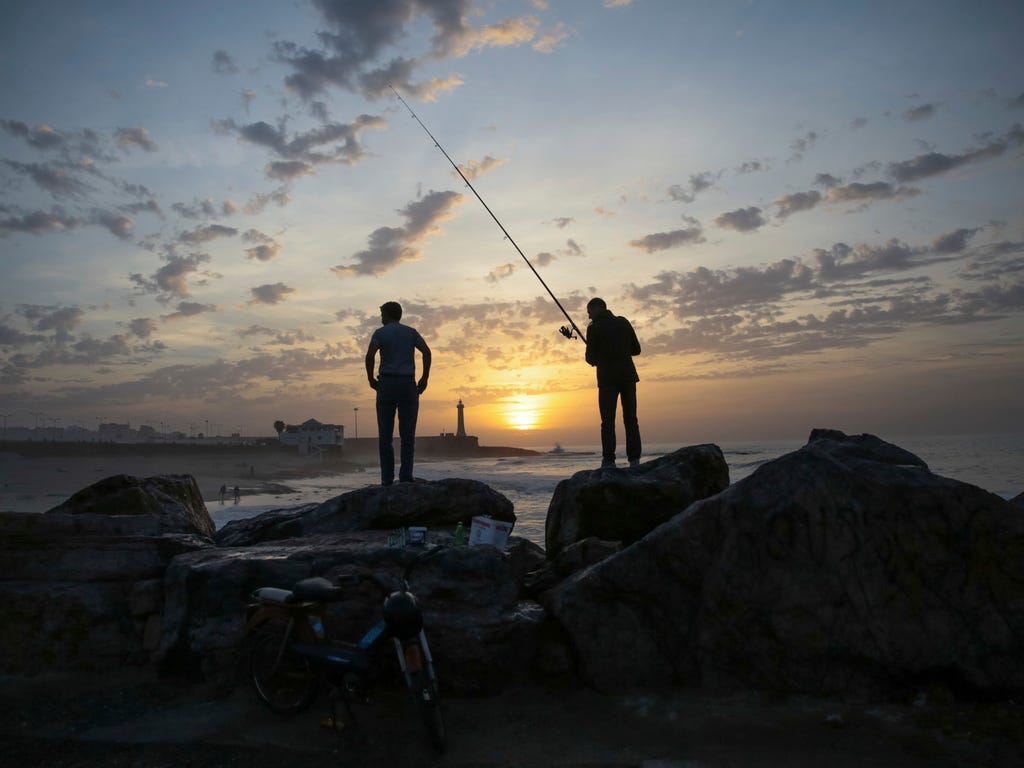 Fishermen wait for a catch on Rabat Beach, Morocco, a gathering place for families and fitness enthusiasts, especially on temperate days.