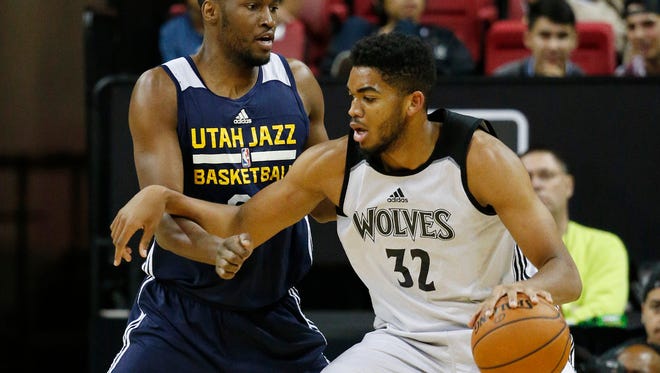 Minnesota Timberwolves’ Karl-Anthony Towns, right, drives into Utah Jazz’s JaJuan Johnson during the first half of an NBA summer league basketball game Monday, July 13, 2015, in Las Vegas. (AP Photo/John Locher)