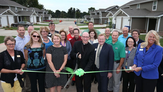 Bishop Edward M Rice (center) performs the ribbon cutting at the second phase of Beacon Village in Springfield on September 9, 2016.