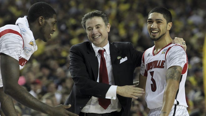 U of L head coach Rick Pitino, center, congratulates Peyton Siva, #3, right, during the closing seconds of their win over Michigan during the NCAA Championship game. Montrezl Harrell, #24, was at left.
Apr. 8, 2013