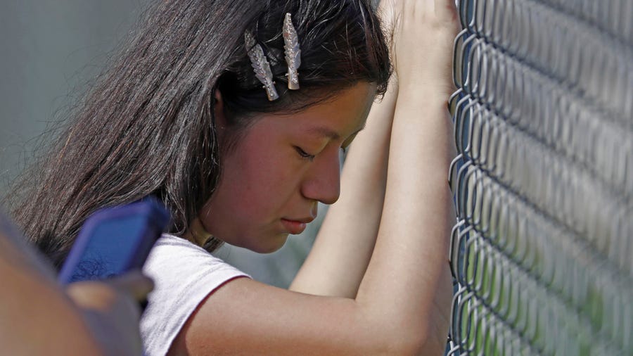A young woman cries outside the Koch Foods plant in Morton, Miss., on Wednesday when immigration authorities raided several food processing plants in the state.