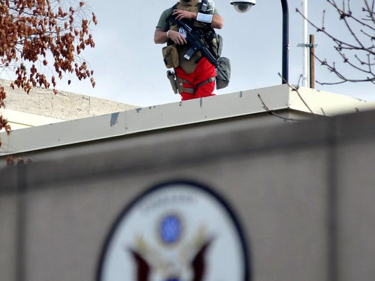 A Marine stands guard on the roof of one of the compounds