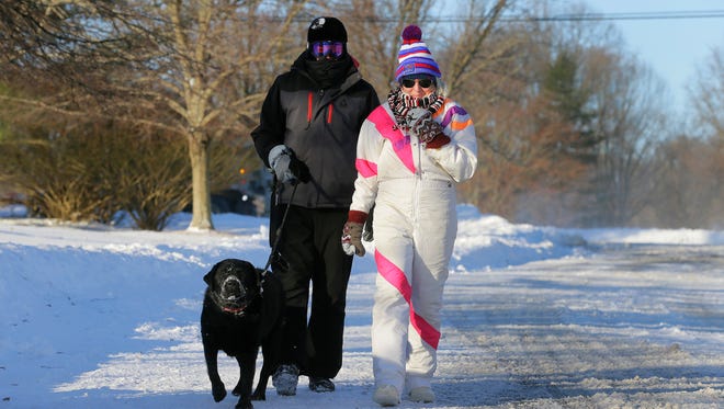 Allen and Cindy Rich of Holmdel walk their dog, Guinness, in the cold temperatures along Linden Court in Holmdel, NJ Friday, January 5, 2018.