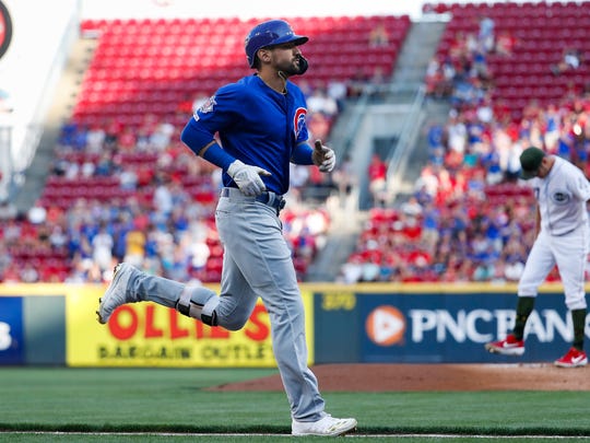 Chicago Cubs' Nicholas Castellanos runs the bases after hitting a solo home run off Cincinnati Reds starting pitcher Trevor Bauer, right, in the first inning of a baseball game, Friday, Aug. 9, 2019, in Cincinnati. (AP Photo/John Minchillo)