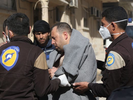 A Syrian man is taken by civil defense workers to a