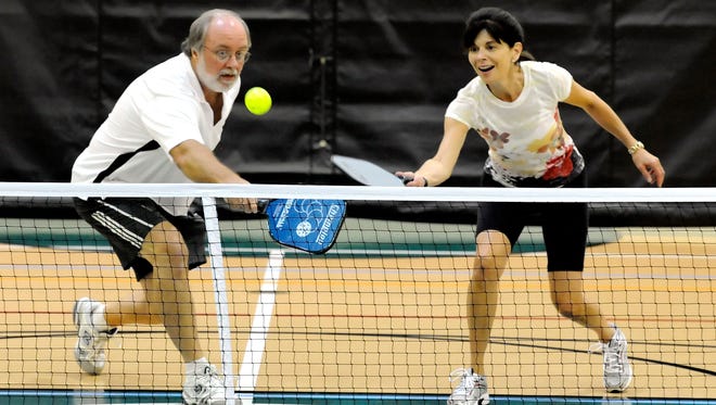 Ted Shaw and Joann MacDaniel rush into together hit the ball over the net while playing doubles pickleball at the Port St. Lucie Civic Center in this file photo.
