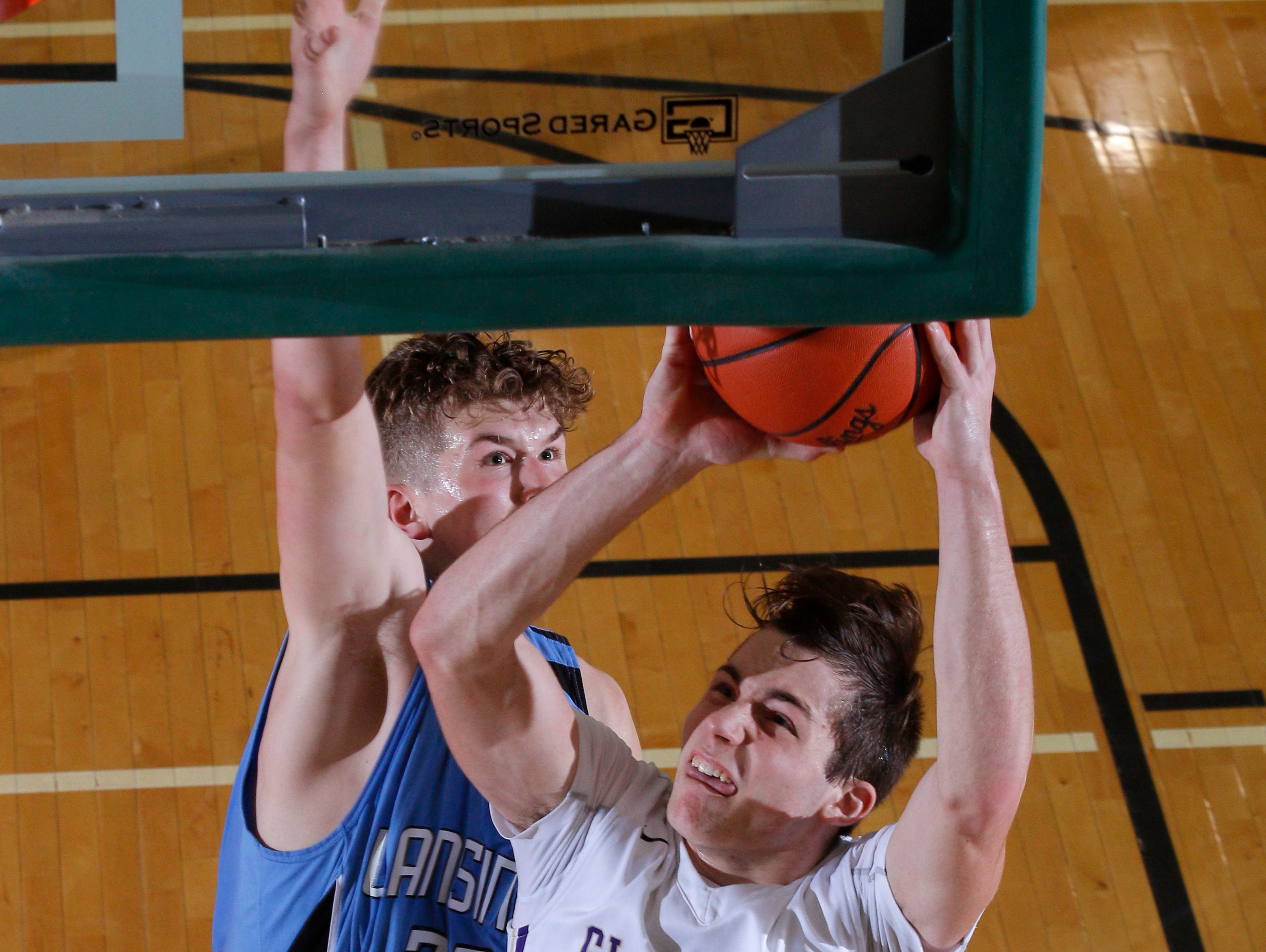 Fowlerville's Geoffrey Knaggs (40) gets a layup in front of Lansing Catholic's Chuck Plaehn during their district game Monday, March 6, 2017, in East Lansing, Mich. Fowlerville won 66-52.