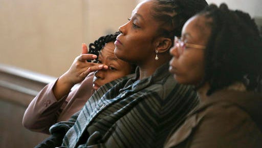 CORRECTS POOL SOURCE TO THE CINCINNATI ENQUIRER - DaShonda Reid, center, Sam DuBose's longtime fiancée, waits for Ray Tensing's pre-trial hearing to begin Friday, Oct. 14, 2016, in Cincinnati. The former University of Cincinnati police officer is charged with killing DuBose, an unarmed black man during a traffic stop over a missing front license plate.     (Amanda Rossmann/The Cincinnati Enquirer via AP, Pool)