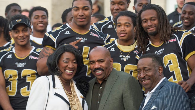 Alabama State University President Gwendolyn Boyd, from left, entertainer Steve Harvey and businessman Greg Calhoun pose with the ASU football team after announcing a partnership between Harvey and ASU in Montgomery, Ala. on Saturday April 2, 2016.  