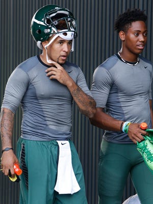 Oregon quarterbacks Vernon Adams, left, and Travis Jonsen head to the locker room after a closed practice in Eugene, Ore, on Aug. 14.