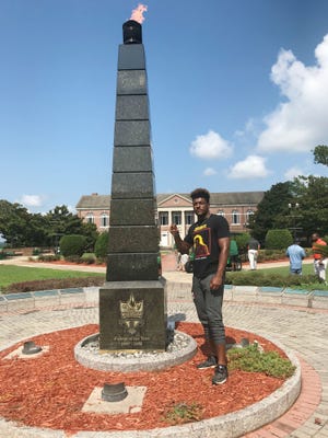 Kayvon Thibodeaux stands by the eternal flame at Florida A&M University.