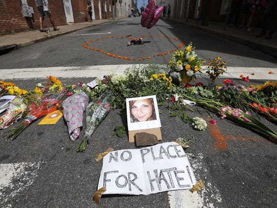 Flowers surround a photo of 32-year-old Heather Heyer, who was killed when a car plowed into a crowd of people protesting against the white supremacist Unite the Right rally on Aug. 13, 2017, in Charlottesville, Virginia.