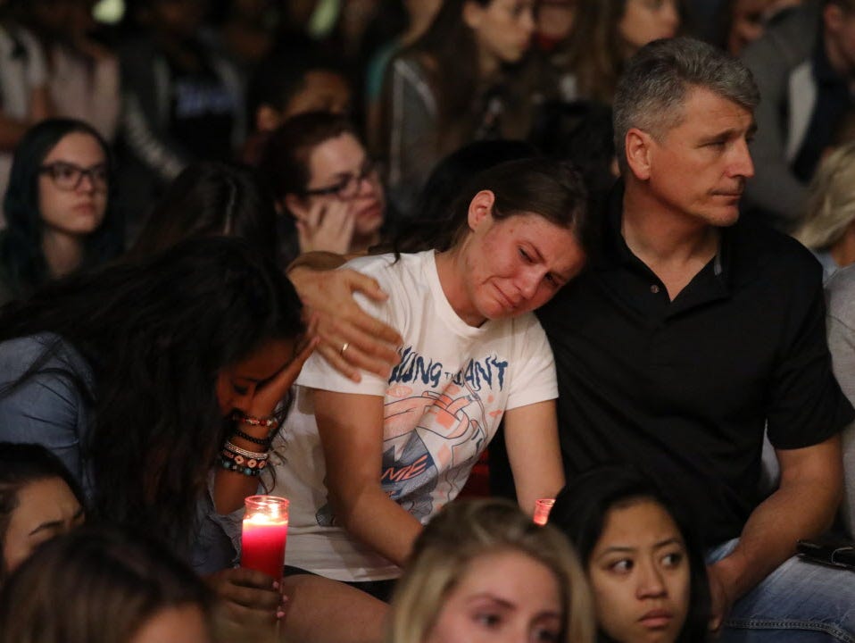 Mourners react during a candlelight vigil at the University of Nevada Las Vegas (UNLV) for victims of a mass shooting in Las Vegas, Nev.
