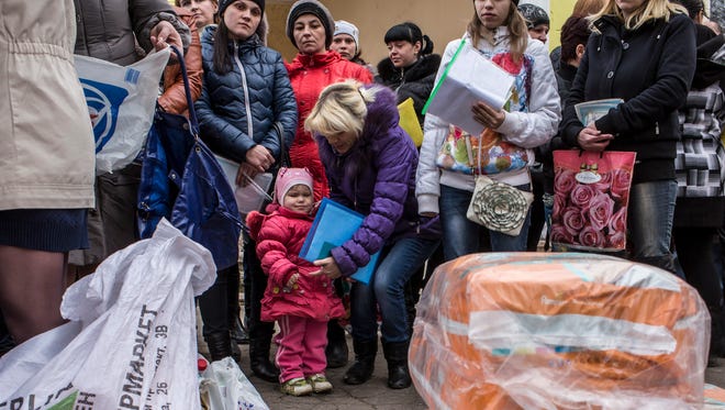 People gather to receive humanitarian aid packages from Responsible Citizens, a Donetsk-based humanitarian assistance organization, on March 12, 2015, in Amvrosiivka, Ukraine.