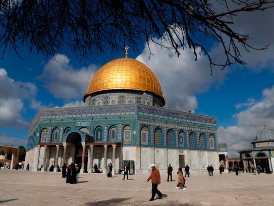 Palestinian Muslim worshippers walk past the Dome of