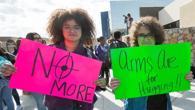 Alma Kassin, 17  and Aubrey Russell, 18, hold out signs during the national school walk out at Las Cruces High School, Wednesday March 14, 2018.
