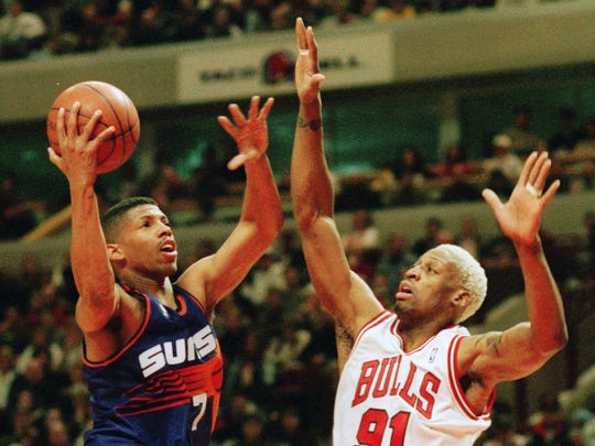 Phoenix Suns' Kevin Johnson drives on Chicago Bulls' Dennis Rodman in 1996.