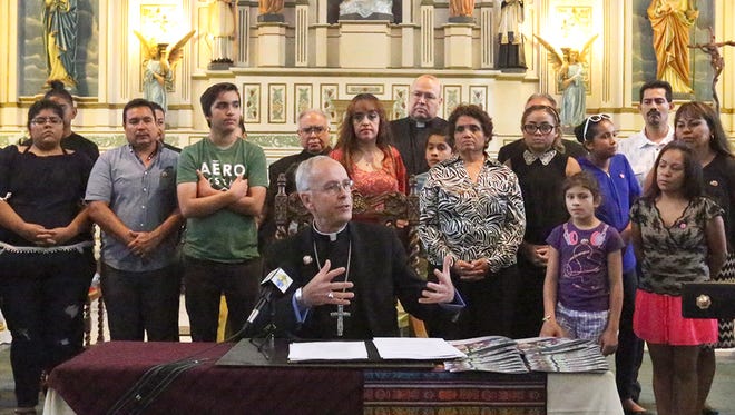 El Paso Catholic Bishop Mark J. Seitz, center, speaks before signing his first pastoral Tuesday at Sacred Heart Catholic Church in South El Paso. The letter is titled “Sorrow and Mourning Flee Away, Pastoral Letter on Migration and the Border.” The bishop spoke on the moral consequences of what he calls a broken immigration system in announcing a number of initiatives to support migrants in the community.