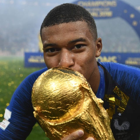 Kylian Mbappe kisses the World Cup trophy after...