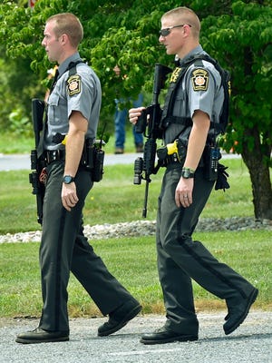 State Police troopers patrol for a fugitive in June  2016.